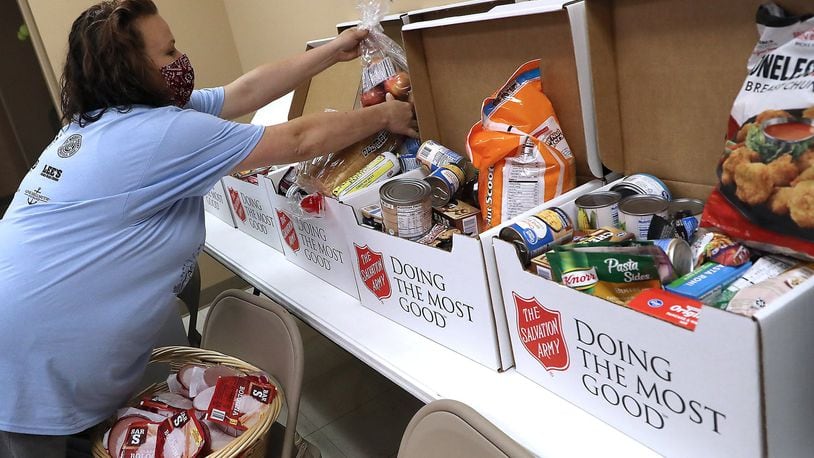 Nicole Hall fills up a food box in the Springfield Salvation Army’s food pantry Friday. BILL LACKEY/STAFF