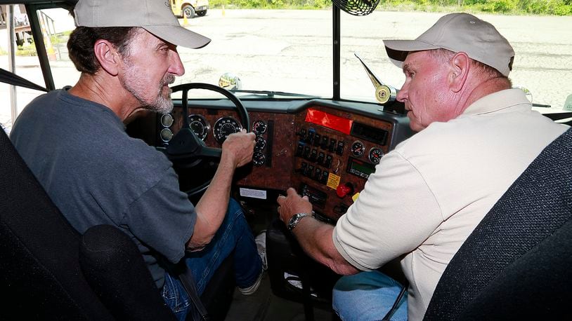 Ed Kelley, left, and Phillip Stechschulte, instructors at the Clark State Truck Driving School, talk in a truck cab. Truck drivers topped the online job openings recently. Bill Lackey/Staff