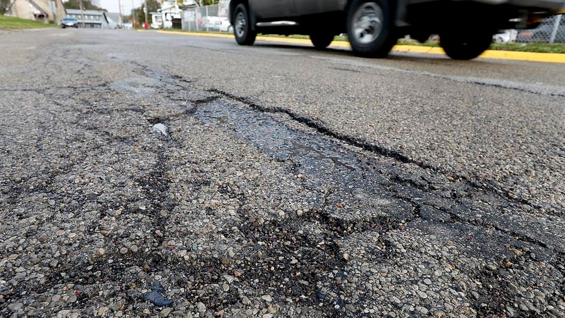 The cracked and broken asphalt along Church Street in South Charleston. Voters approved a roads levy, which would raise $954k over 8 years through a 0.25 percent income tax increase. Bill Lackey/Staff