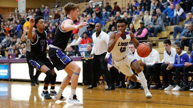 Emanuel Christian Academy’s Jason Channels drives past Cincinnati Christian’s Cody Anderson during their Division IV district final game on Friday night at the Vandalia Butler Student Activity Center. CONTRIBUTED PHOTO BY MICHAEL COOPER