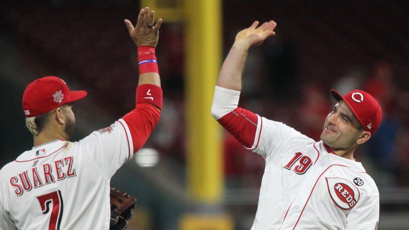 Reds first baseman Joey Votto, right, and third baseman Eugenio Suarez celebrate after the final out of a victory against the Braves on Tuesday, April 23, 2019, at Great American Ball Park in Cincinnati. David Jablonski/Staff