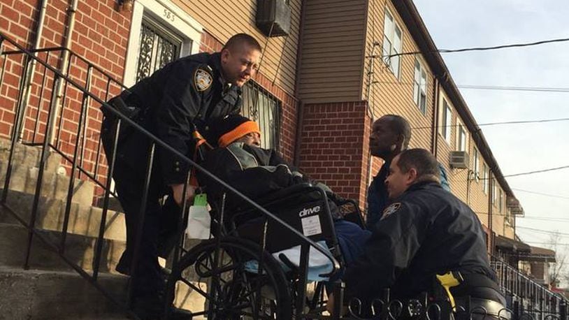 Police helped a veteran in a wheelchair up the steps to his apartment Saturday. (Photo: NYPD)
