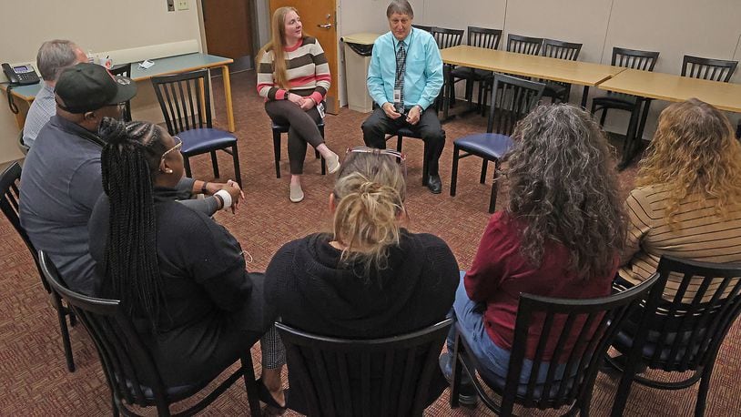 Erin Foster and Andrew Lohrer, both from Mental Health Services of Clark and Madison County, hold a group session with  people Tuesday at the Mental Health Services building on North Yellow Springs Street. BILL LACKEY/STAFF