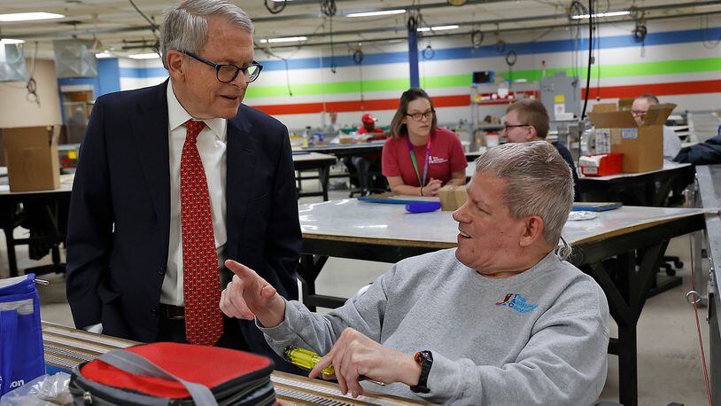 Ohio Gov. Mike DeWine visits with associates at The Abilities Connection Monday, March 20, 2023, as he tours the Springfield facility. BILL LACKEY/STAFF