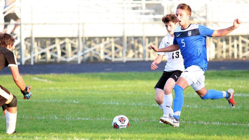Northwestern High School’s Evan Noffke and Shawnee’s Matt Holland chase the ball as it rolls towards the Braves’ goal during the Warriors 5-1 win over Shawnee on Monday, Sept. 17. Michael Cooper/CONTRIBUTED