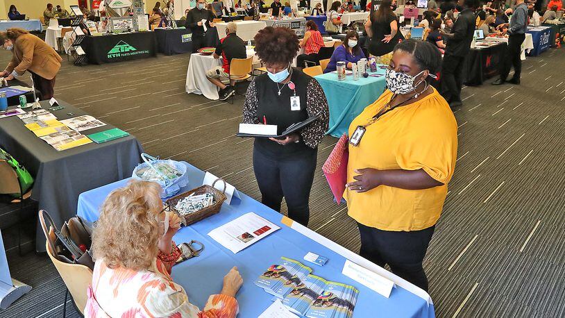 Angeline Chapman, right, and Imani McPheters, both from Ohio Means Jobs, talk to employers during a job fair in Clark County last year. BILL LACKEY/STAFF