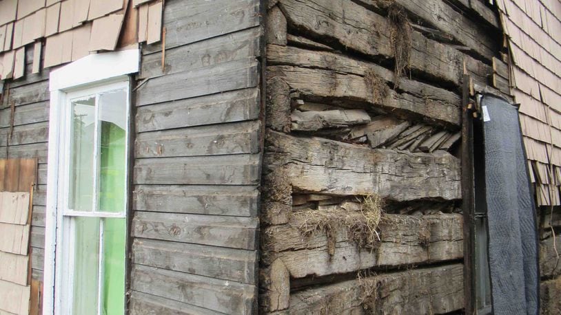 Two centuries of architectural history is revealed. Two layers of siding were removed to reveal the original wall of the cabin which was built in 1810. The ends of the logs visible at the corner show a “V Notch” style of notching. Photo by David McWhorter.