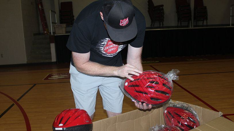 Ryan Ray with The Salvation Army Springfield Corps. looks over some of the helmets that were donated by Clark County-Springfield Transportation Coordinating Committee. JEFF GUERINI/STAFF