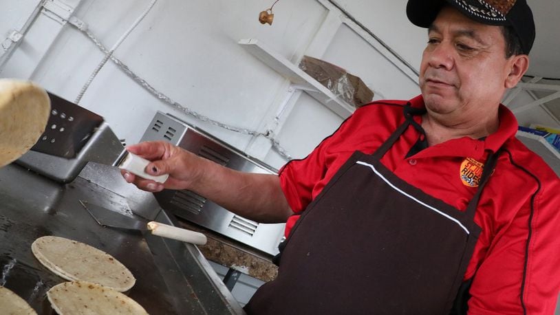Cabrera-Caudillo Apolinar flips tortillas in his food truck in New Carlisle Wednesday. New Carlisle changes its rules for food trucks, allowing them to stay open year round. Bill Lackey/Staff