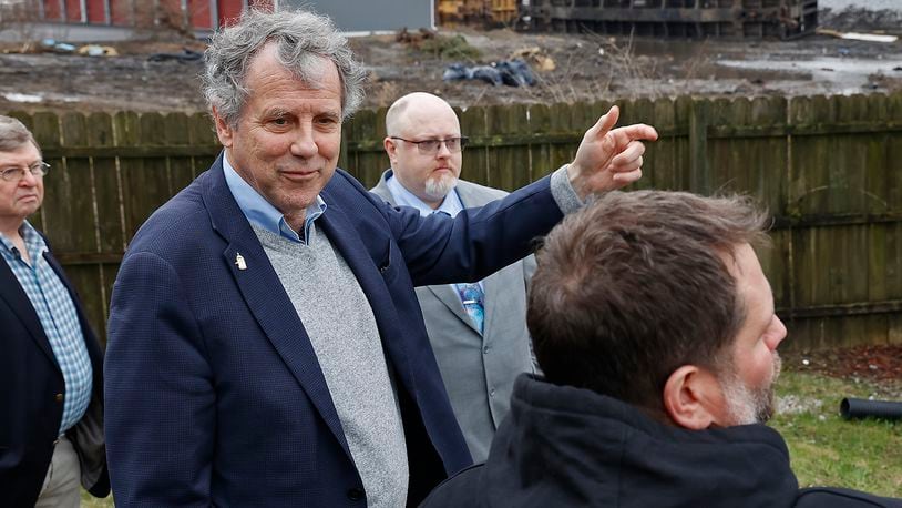 Sen. Sherrod Brown talks to Clark County business owner Lane Martin Friday, March 24, 2023 about the train derailment that occurred earlier this month next to his business. BILL LACKEY/STAFF