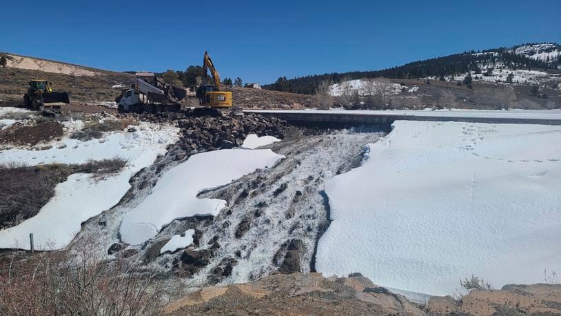 In this photo provided by the Utah Division of Water Rights, crews use heavy machinery to place boulders downstream of the cracked Panguitch Lake Dam to reinforce the wall, Wednesday, April 10, 2024, in Panguitch, Utah. (Matt Call/Utah Division of Water Rights via AP)