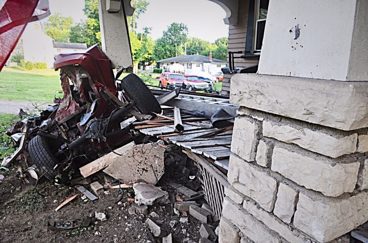 Tanker truck strikes pole, porch, other cars