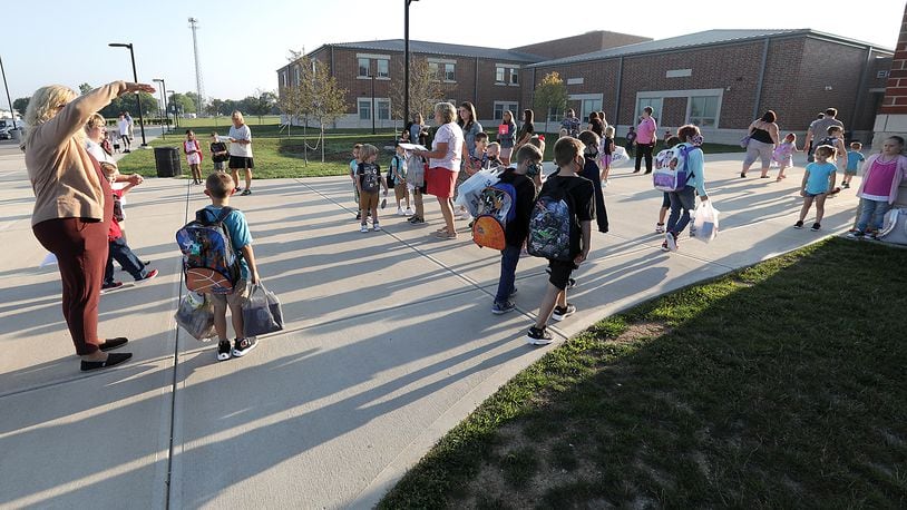 Urbana schools will require masks starting Monday. Here, children walk into Urbana Elementary and Junior High School for the first day of school in August. BILL LACKEY/STAFF