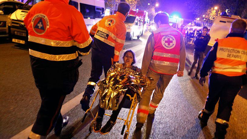 A person is being evacuated after a shooting, outside the Bataclan theater in Paris, Saturday, Nov. 14, 2015. A series of attacks targeting young concert-goers, soccer fans and Parisians enjoying a Friday night out at popular nightspots killed over 100 people in the deadliest violence to strike France since World War II.(AP Photo/Thibault Camus)