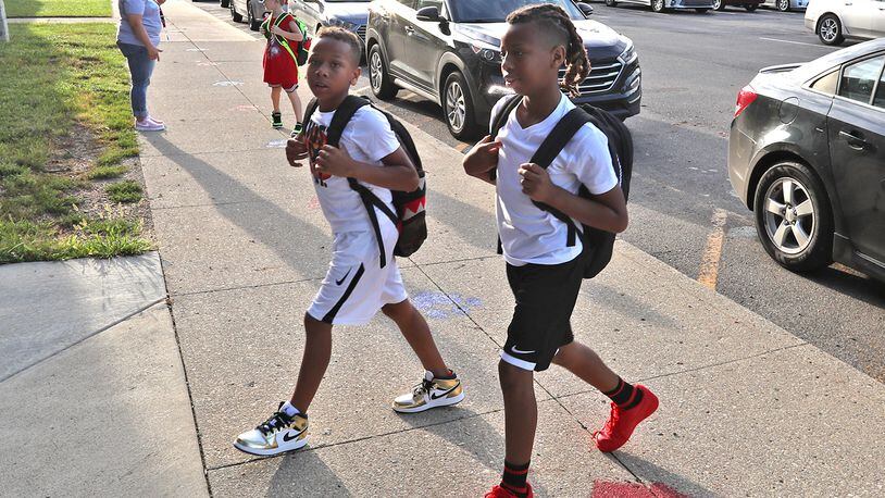 Students walk into Lagonda Elementary for the first day school Wednesday morning. BILL LACKEY/STAFF