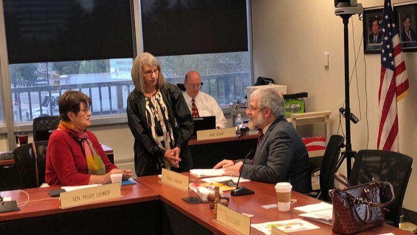 State school board member Pat Bruns (standing), who represents Warren County, talks to state Senator Peggy Lehner, R-Kettering, and State Superintendent Paolo DeMaria before Tuesday’s state school board meeting in Columbus. JEREMY P. KELLEY / STAFF