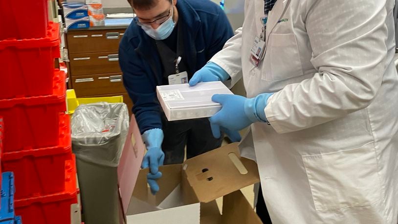 Two Springfield Regional Medical Center employees handle their shipment of the Pfizer COVID-19 vaccine on Tuesday, Dec. 15, 2020. Staff vaccinated last month will begin receiving their second dose of the vaccine this week. Contributed