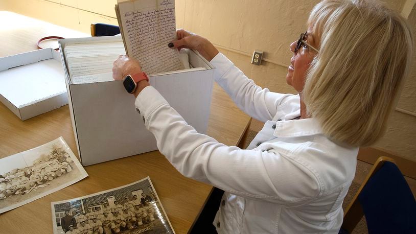 Susan Hamilton, looks over a box full of letters that her father, Floyd "Junie" Mitch, wrote to his family while in World War II. BILL LACKEY/STAFF