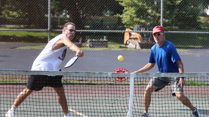 Dave Gordin, left, and Ten Ober play pickle ball at Snyder Park in August. The tennis/pickle ball courts are scheduled to by resurfaced later this year. BILL LACKEY/STAFF