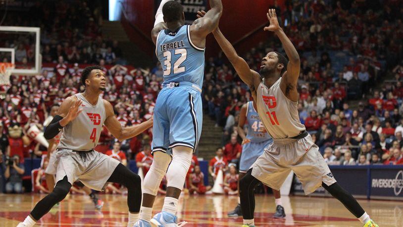 Rhode Island’s Jared Terrell, center, passes against Dayton’s Charles Cooke, left, and Scoochie Smith on Saturday, Feb. 27, 2016, at UD Arena in Dayton. David Jablonski/Staff