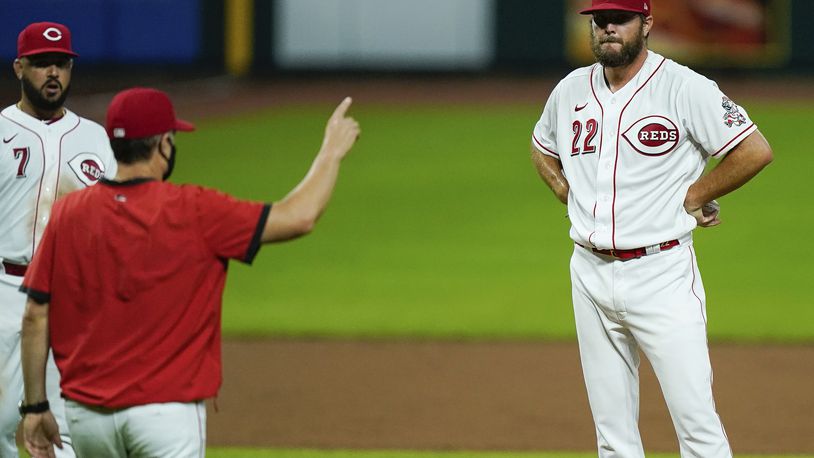 Cincinnati Reds starting pitcher Wade Miley stands on the mound as manager David Bell signals for a new pitcher during the second inning of the team's baseball game against the Chicago Cubs in Cincinnati, Monday, July 27, 2020. (AP Photo/Bryan Woolston)