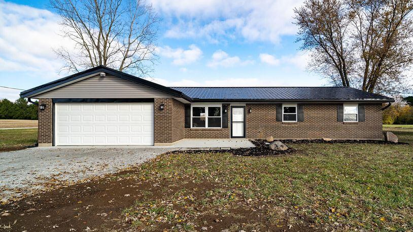 The front of the home features a long gravel driveway, two-car attached garage and oversized concrete front porch. The home has a new metal roof. Contributed photos