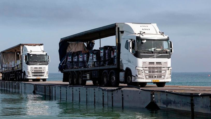 Trucks loaded with humanitarian aid from the United Arab Emirates and the United States Agency for International Development cross the Trident Pier before entering the beach in Gaza, May 17, 2024. (Staff Sgt. Malcolm Cohens-Ashley/U.S. Army Central via AP)