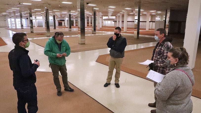 Members of the Clark County Land Bank and Clark County Combined Health District discuss how the Health Department will utilize the former JC Penny location at the Upper Valley Mall Wednesday. BILL LACKEY/STAFF