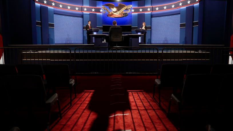 The moderator casts a long shadow as students stand in for the candidates during a rehearsal Tuesday, Oct. 18, 2016 for the third presidential debate between Republican presidential nominee Donald Trump and Democratic presidential nominee Hillary Clinton at UNLV in Las Vegas. (AP Photo/John Locher)