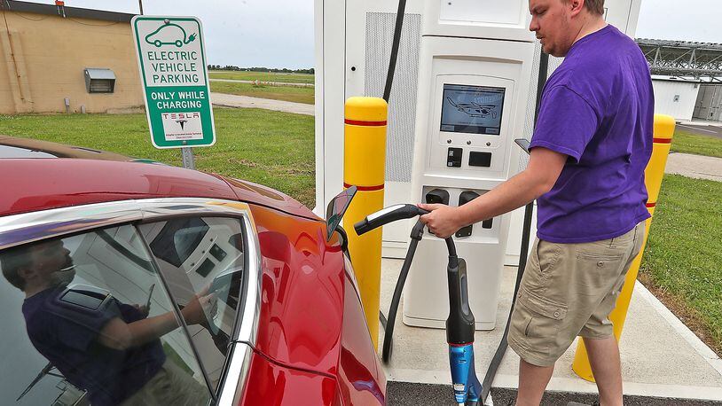 Austin Eggers plugs in his Tesla electric car at the charging station at Springfield Beckley Municipal Airport Friday, June 10, 2022. BILL LACKEY/STAFF