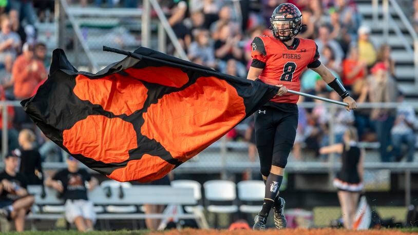 West Liberty-Salem High School senior Miles Hostetler waves a Tigers flag before their game against Northeastern earlier this season at Tiger Stadium in West Liberty. Michael Cooper/CONTRIBUTED