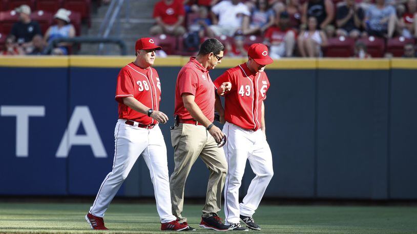 Scott Schebler of the Cincinnati Reds leaves the game after being injured making a diving catch in right field in the sixth inning of a game against the Atlanta Braves at Great American Ball Park on June 3, 2017 in Cincinnati, Ohio. The Braves defeated the Reds 6-5 in 12 innings. (Photo by Joe Robbins/Getty Images)