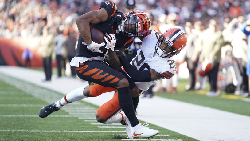 Cincinnati Bengals' Ja'Marr Chase (1) is tackled by Cleveland Browns' Greg Newsome II (20) during the second half of an NFL football game, Sunday, Nov. 7, 2021, in Cincinnati. (AP Photo/Bryan Woolston)