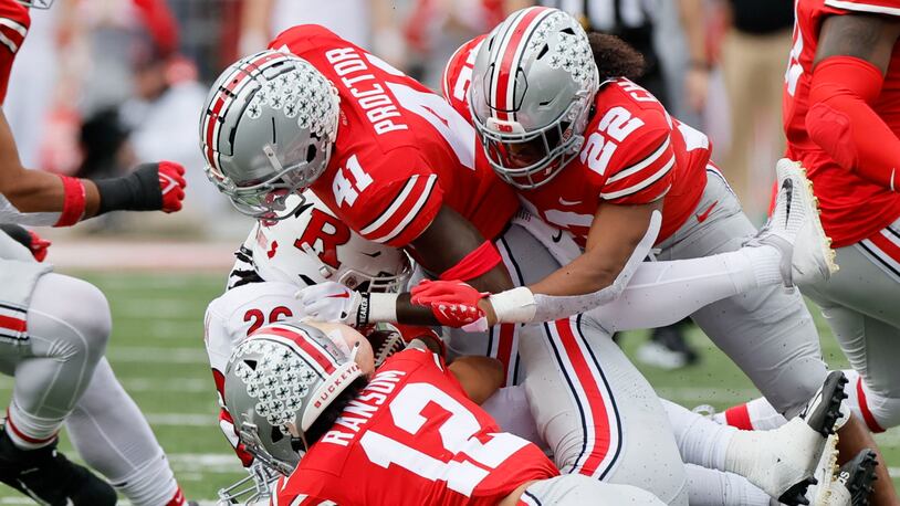Ohio State defensive back Josh Proctor, top, linebacker Steele Chambers, right, and defensive back Lathan Ransom, front, tackle Rutgers running back Al-Shadee Salaam during the first half of an NCAA college football game Saturday, Oct. 1, 2022, in Columbus, Ohio. (AP Photo/Jay LaPrete)