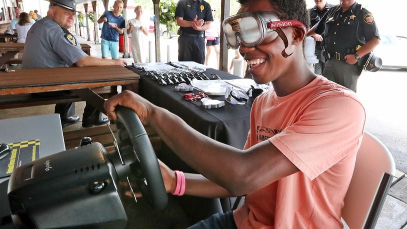 Pierre Bowman, 14, tries to operate a driving simulator with a pair of Fatal Vision, drunk goggles, on Friday during the Drive Sober or Get Pulled Over campaign kickoff at Youngs Jersey Dairy. BILL LACKEY/STAFF 