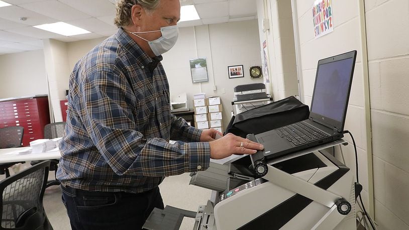 Clark County Board of Elections employee Martin Mahoney starts up one of the machines used to scan mail-in ballots at the Board of Elections last year. BILL LACKEY/STAFF