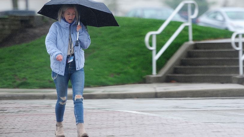 An umbrella helped keep some of the rain off a woman walking on Brown Street Monday, April 12, 2020. MARSHALL GORBY\STAFF