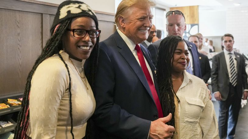 Republican presidential candidate former President Donald Trump, center, takes a photo with customers as he visits a Chick-fil-A eatery, Wednesday, April 10, 2024, in Atlanta. (AP Photo/Jason Allen)