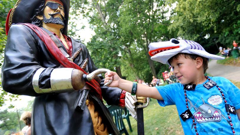 In this file photo, Parker Sothard, 4, shakes hands or hooks with the pirate statue at Veterans Park during the Parrothead Party in the Park as a warm-up to the Summer Arts Festival. BILL LACKEY/STAFF