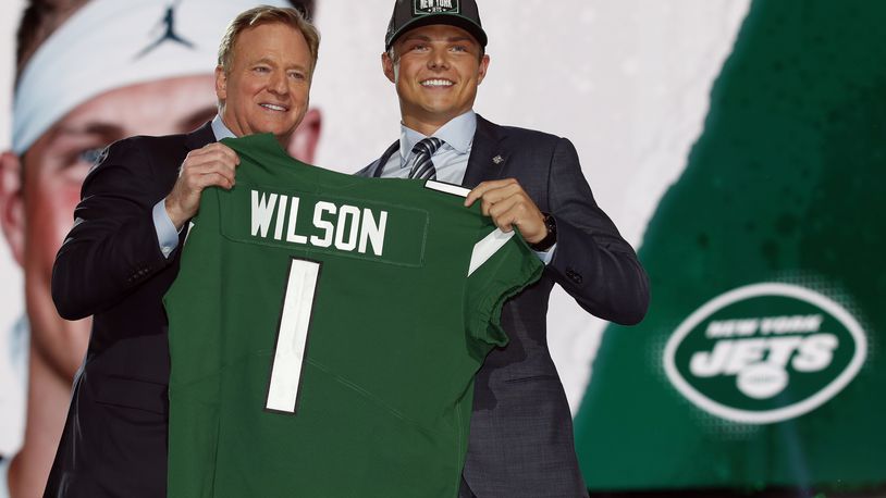 FILE - BYU quarterback Zach Wilson holds a New York Jets jersey with NFL commissioner Roger Goodell after being selected second overall by the team in the first round of the NFL football draft, Thursday, April 29, 2021, in Cleveland. Teams are using premium draft picks on quarterbacks at an increasingly high rate. Still, the league-wide hit rate remains largely a tossup. (AP Photo/Jeff Haynes, File)