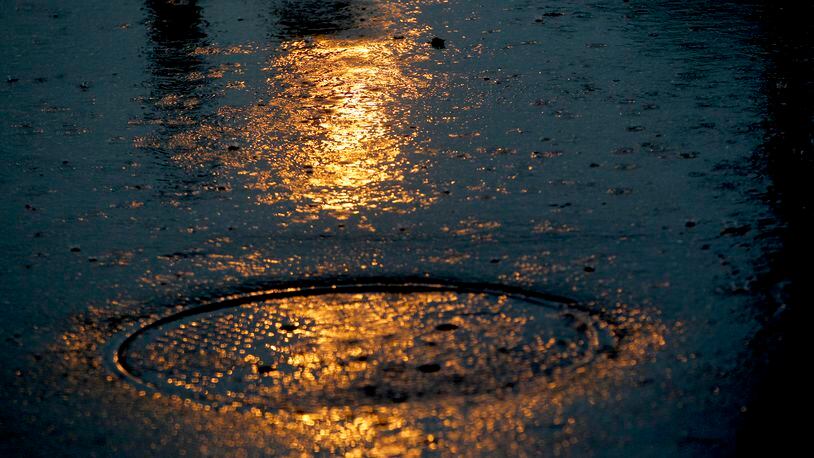 Rain falls across a parking lot in Dayton.  LISA POWELL / STAFF