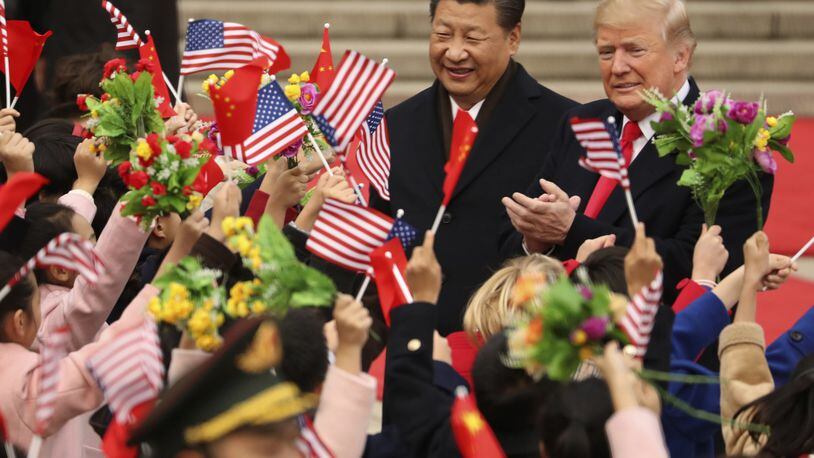 FILE - In this Nov. 9, 2017, file photo, President Donald Trump and Chinese President Xi Jinping participate in a welcome ceremony at the Great Hall of the People in Beijing, China. Trump couldn’t seem to stop talking about the red carpets, military parades and fancy dinners that were lavished upon him during “state visits” on his recent tour of Asia. “Magnificent,” he declared at one point on the trip. But Trump has yet to reciprocate in kind. In fact, he is the first president in decades to close his first year in office without welcoming a counterpart on a visit to the U.S. with similar trappings. (AP Photo/Andrew Harnik, File)