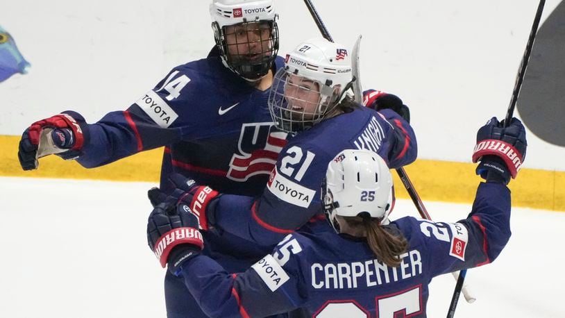 United States' Laila Edwards (14) celebrates after her goal over Finland with teammates Hilary Knight (21) and Alex Carpenter (25) during the second period in the semifinals of the IIHF women's world hockey championships Saturday, April 13, 2024, in Utica, N.Y. (Christinne Muschi/The Canadian Press via AP)