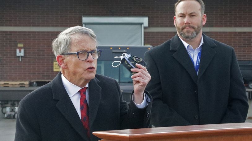 Gov. Mike DeWine reminds residents that they still need to wear a mask Tuesday, Dec. 15, 2020, as Springfield Regional Medical Center President Adam Groshans listens shortly after the first vaccine arrives at the hospital. BILL LACKEY/STAFF