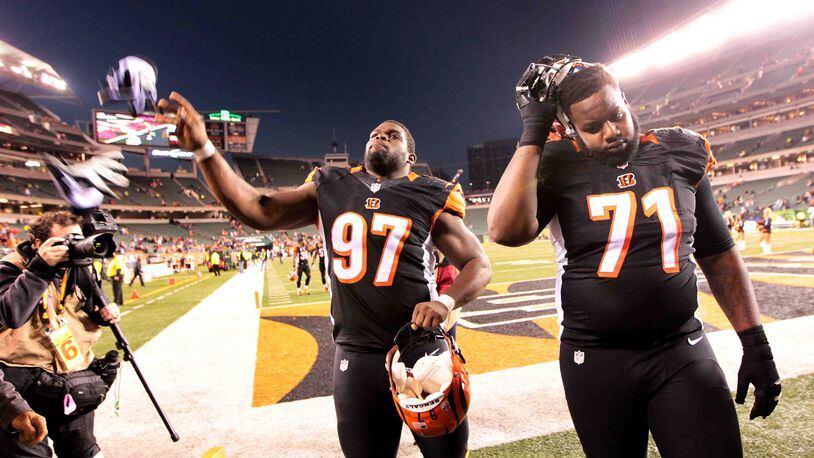 Cincinnati Bengals defensive tackle Geno Atkins (97) and Andre Smith (71) leave the field after Sunday's victory over the Jets at Paul Brown Stadium in Cincinnati, Ohio, Oct. 27, 2013. NICK DAGGY / STAFF