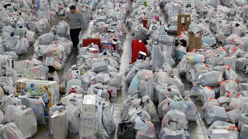 ORIGINAL CUTLINE: Melissa Jeffery, a Salvation Army volunteer, walks through a sea of plastic bags, each containing Christmas presents for a needy child, as she helps sort presents for the more than 2,000 children the Springfield Salvation Army is helping this Christmas. BILL LACKEY/STAFF