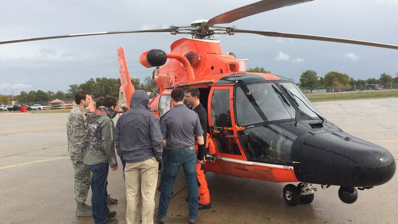 A student capstone team from Michigan Technological University gets a close look at a maritime rescue helicopter during an Oct. 19, 2018, team gathering. The group is collaborating with the Air Force Research Laboratory and the U.S. Coast Guard to design a compact, high-capacity maritime rescue device. (Photo courtesy of Mark Bobal, U.S. Coast Guard)