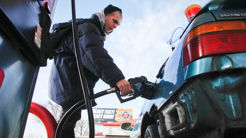 Gabriel Fletcher of Dayton pumps gas for his mother Jan 4, 2013 at a Dayton gas station. STAFF PHOTO BY LISA POWELL