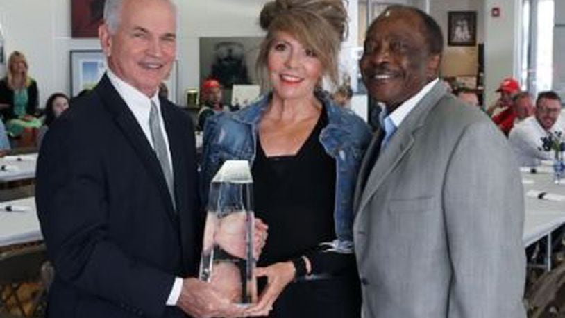 Roger Quandt, American Honda Motor Co. Inc., Central Zone parts and service manager, hands Joe and Teresa Morgan the Honda President s Award on May 16. Joe Morgan Honda in Monroe has won the award for six consecutive years. Contributed photo