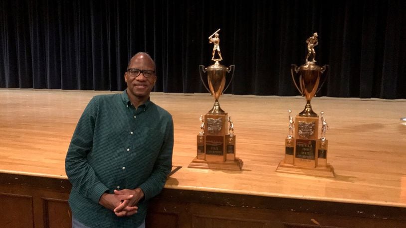 New York times best-selling author author, award-winning journalist and Miami University former basketball player, grad and distinguished visiting professor Wil Haygood at East High with championship trophies from 1968-69. Haygood will appear three times in Dayton over the next month (as part of UD Speaker Series on Tuesday, as part of Dayton Literary Peace Prize Community Conversations on Oct. 11 at the Dayton Metro Library and at Books a Million in The Greene Oct. 26. Tom Archdeacon/STAFF